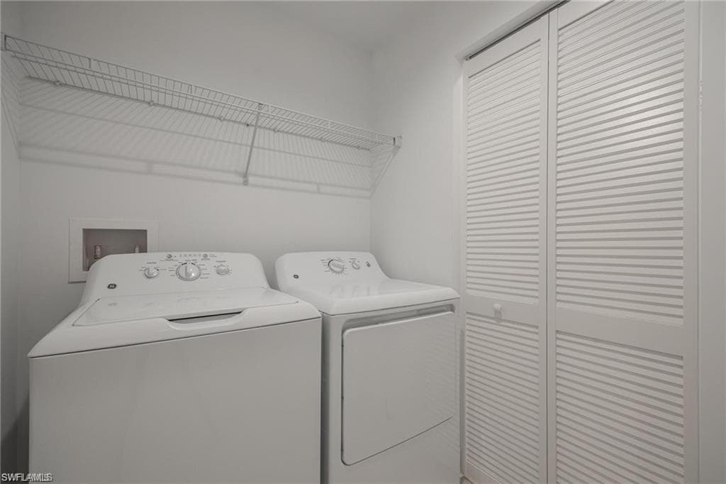 Washroom featuring independent washer and dryer and laundry area