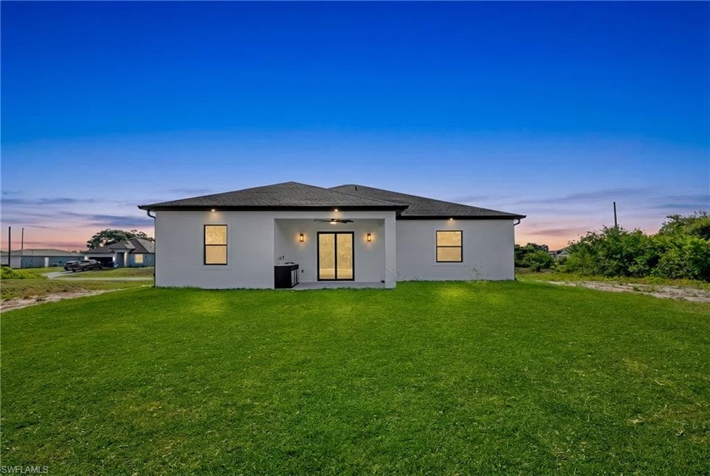 Contemporary stucco exterior with a covered patio featuring a ceiling fan and recessed lighting