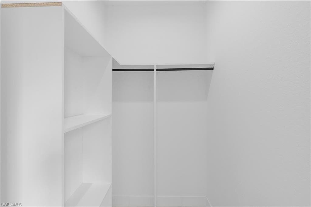 Integrated white shelving system with a built-in hanging rod, offering versatile storage