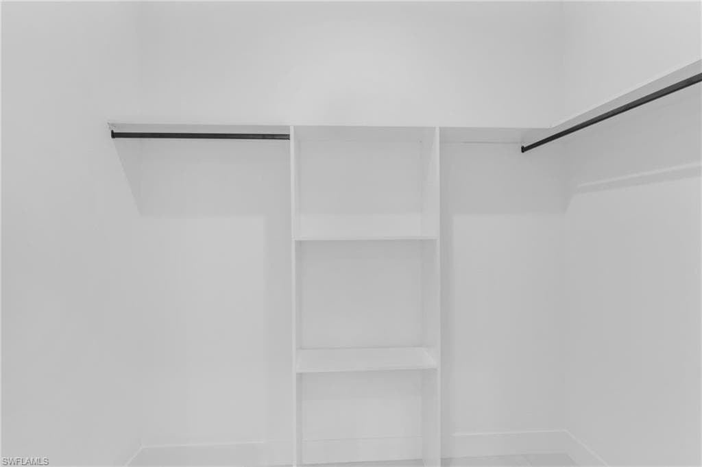White closet system featuring built-in shelving and dual hanging rods