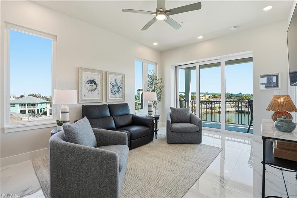 Living area with recessed lighting, ceiling fan, and marble finish floors - Virtually Edited Image