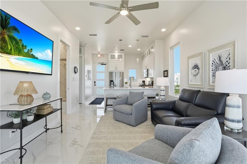 Living room with recessed lighting, ceiling fan, and light marble finish flooring - Virtually Edited Image
