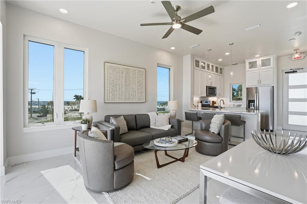 Living area with recessed lighting, light marble finish floors, and ceiling fan - Virtually Edited Image