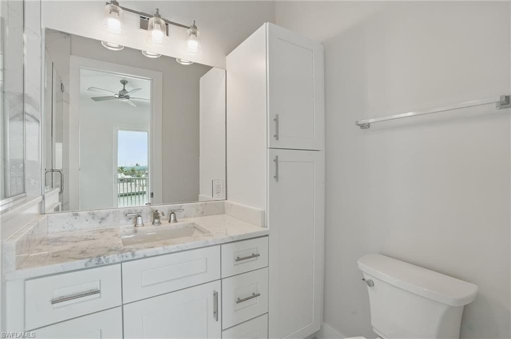 Master Bathroom featuring vanity, toilet, and a ceiling fan - VIRTUALLY EDITED