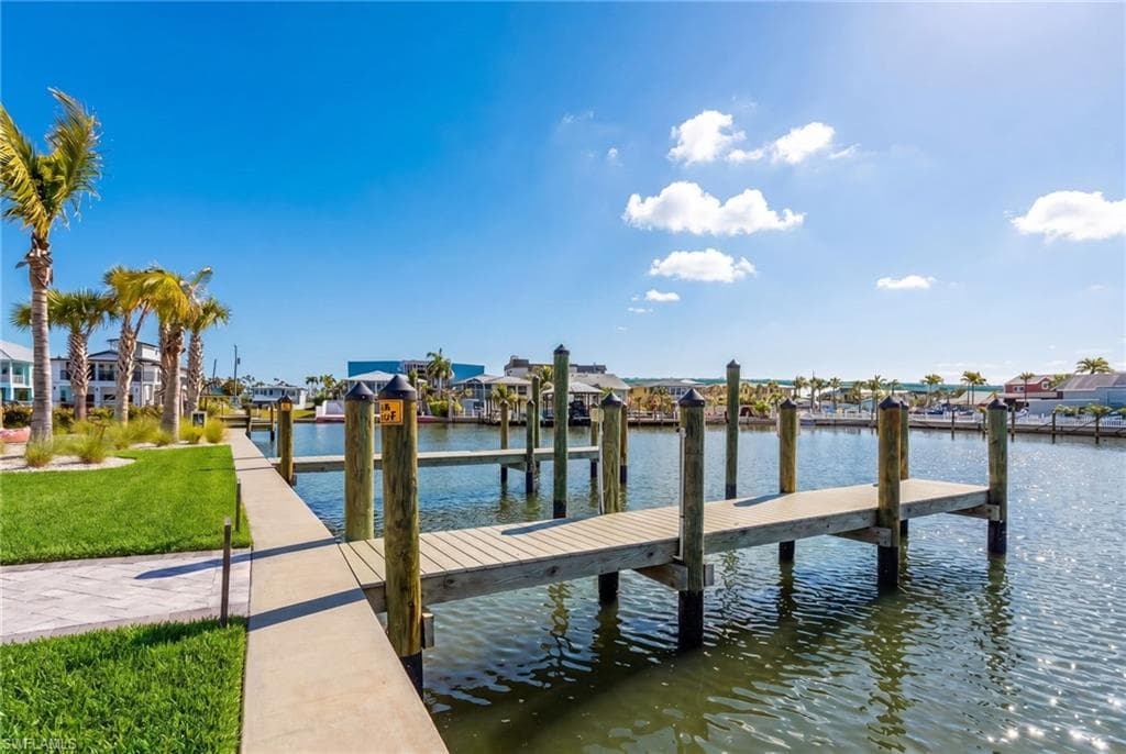 Waterfront concrete walkway bordered by manicured lawn and mature palm trees - Virtually Edited Image
