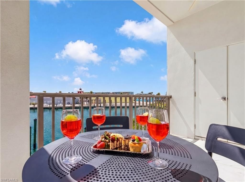Waterfront balcony featuring a light railing, solid exterior wall, and a painted concrete floor - Virtually Edited Image