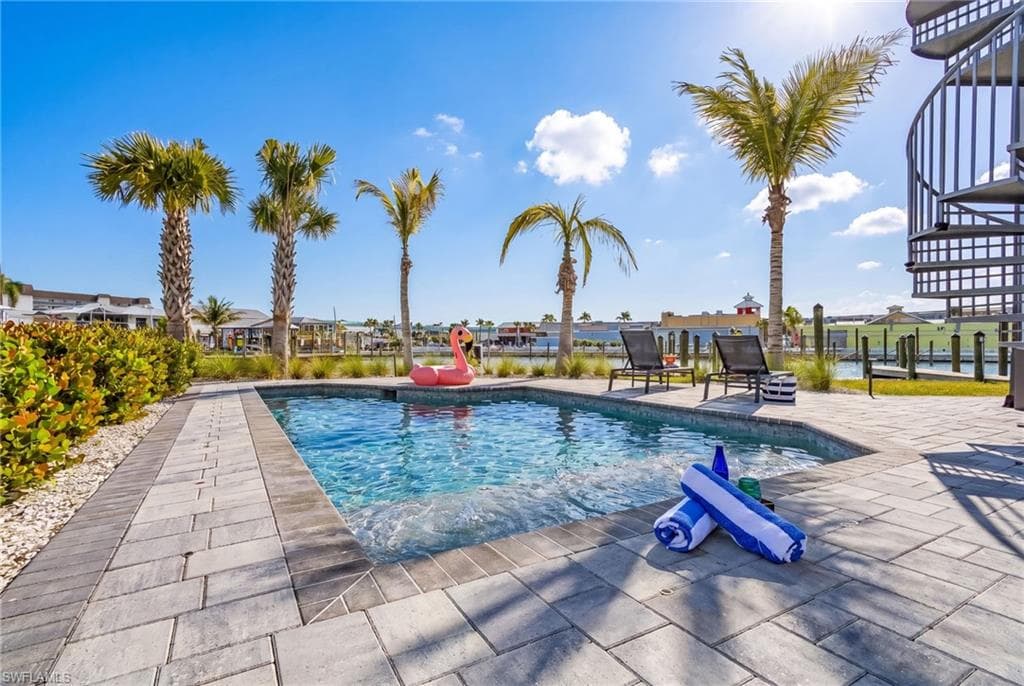 Private backyard oasis featuring a rectangular swimming pool with integrated spa, surrounded by paver patio decking - Virtually Edited Image