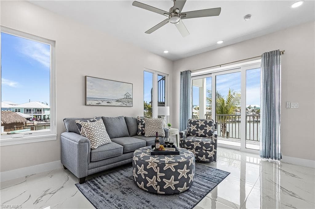 Spacious living area featuring polished tile flooring, recessed lighting, and a ceiling fan - Virtually Edited Image