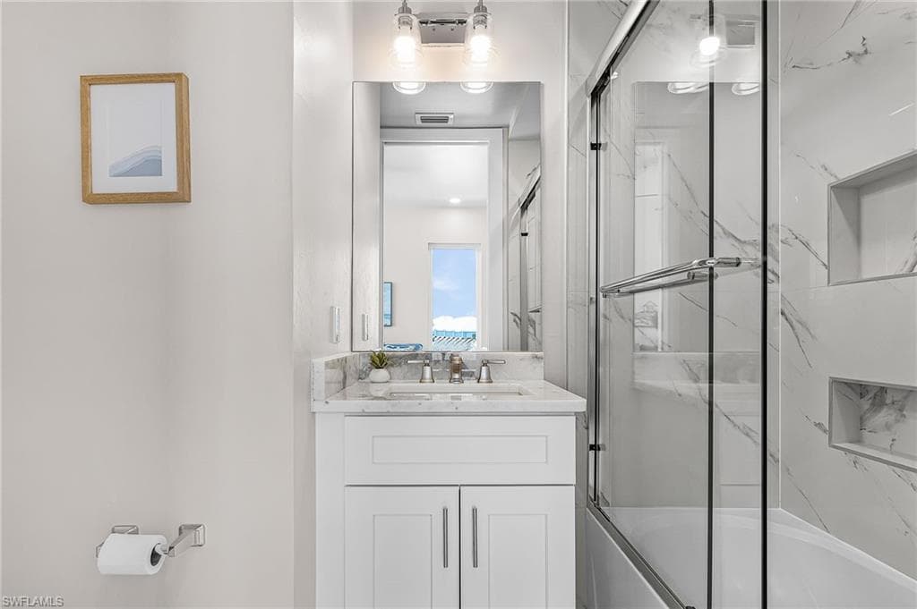 Bathroom featuring a white vanity with a light-toned countertop, a rectangular mirror, and an overhead light fixture - Virtually Edited Image