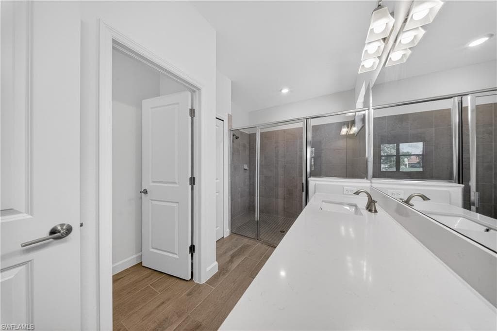 Bathroom featuring a dual vanity with a white countertop, chrome fixtures, and a large mirror