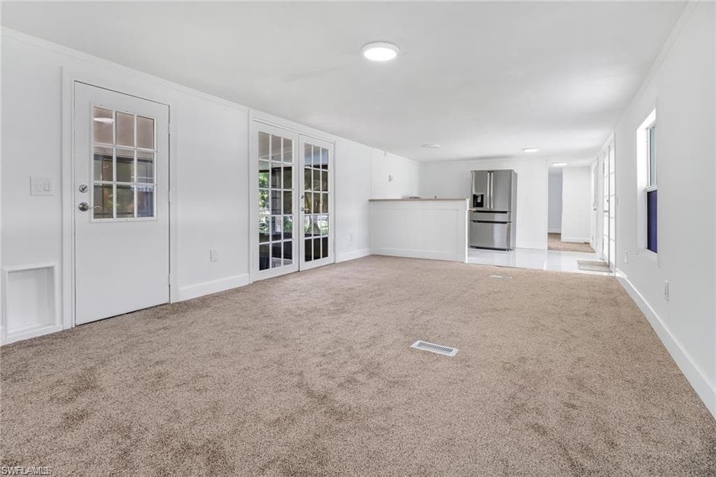 room with light colored carpet and baseboards