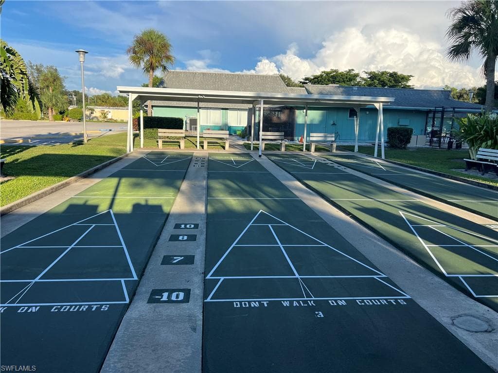 View of community with a yard, a patio, and shuffleboard
