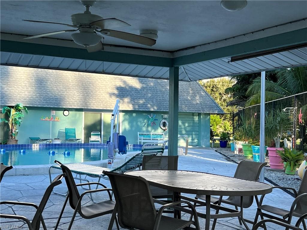 View of patio featuring ceiling fan,dining space, and a community pool