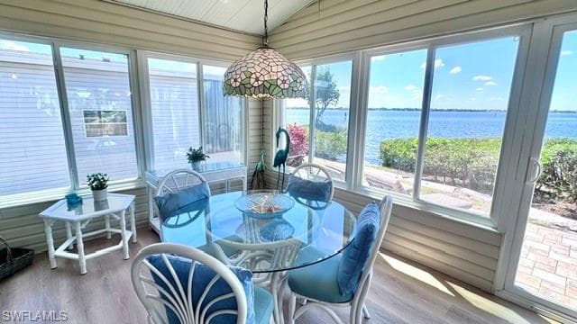 Waterfront sunroom featuring expansive windows