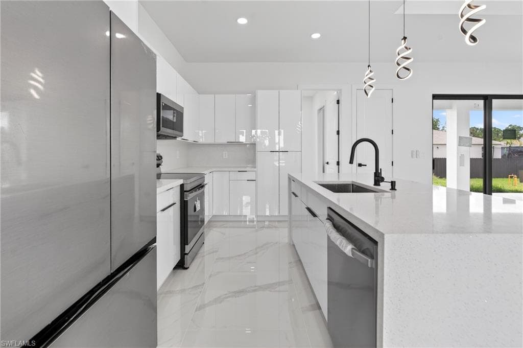 Contemporary kitchen with a large center island, white gloss cabinetry, stainless steel appliances, a black gooseneck faucet, and marble-look floor tiling