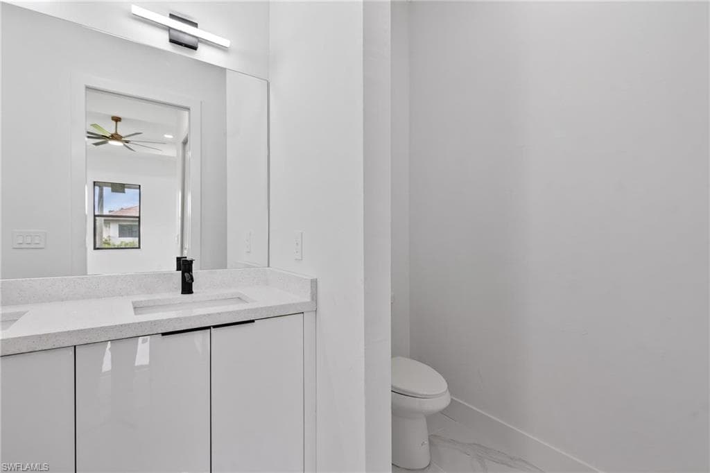 Bathroom vanity featuring a quartz countertop with an integrated rectangular sink, matte black faucet, and white high-gloss cabinetry
