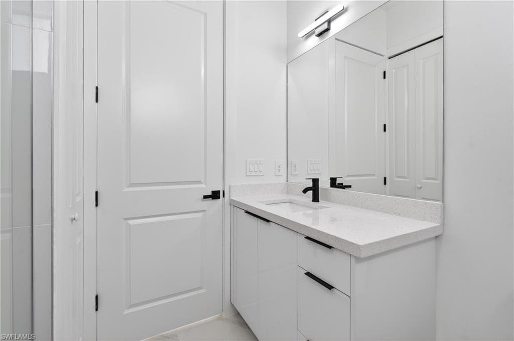 Modern bathroom vanity featuring a quartz-finish countertop and integrated sink