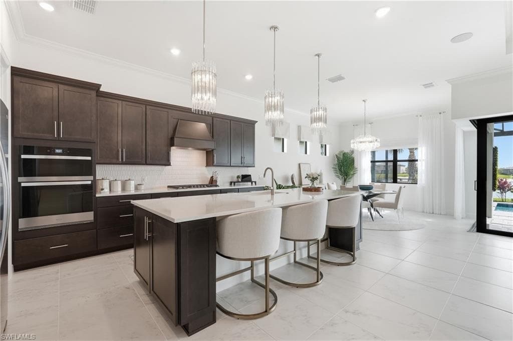 Gourmet Kitchen, Quartz Countertops, Furniture Style Island with Seating and Elegant Pendant Lighting