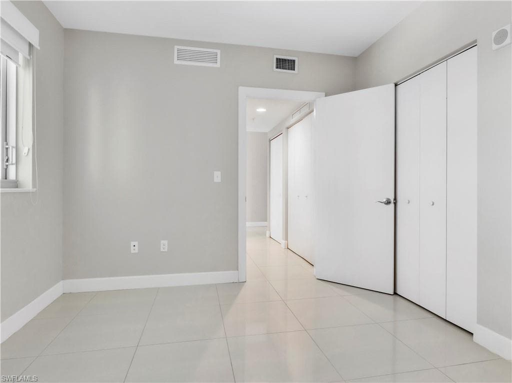 Unfurnished bedroom with light tile patterned floors and a closet