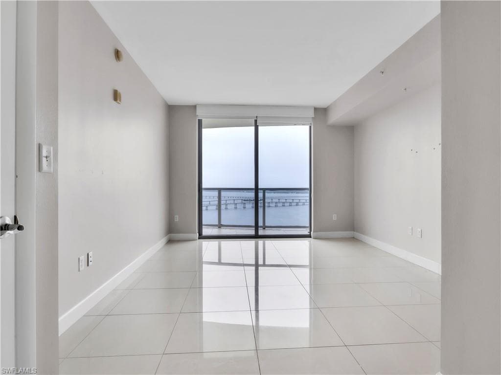 Empty room with light tile patterned flooring