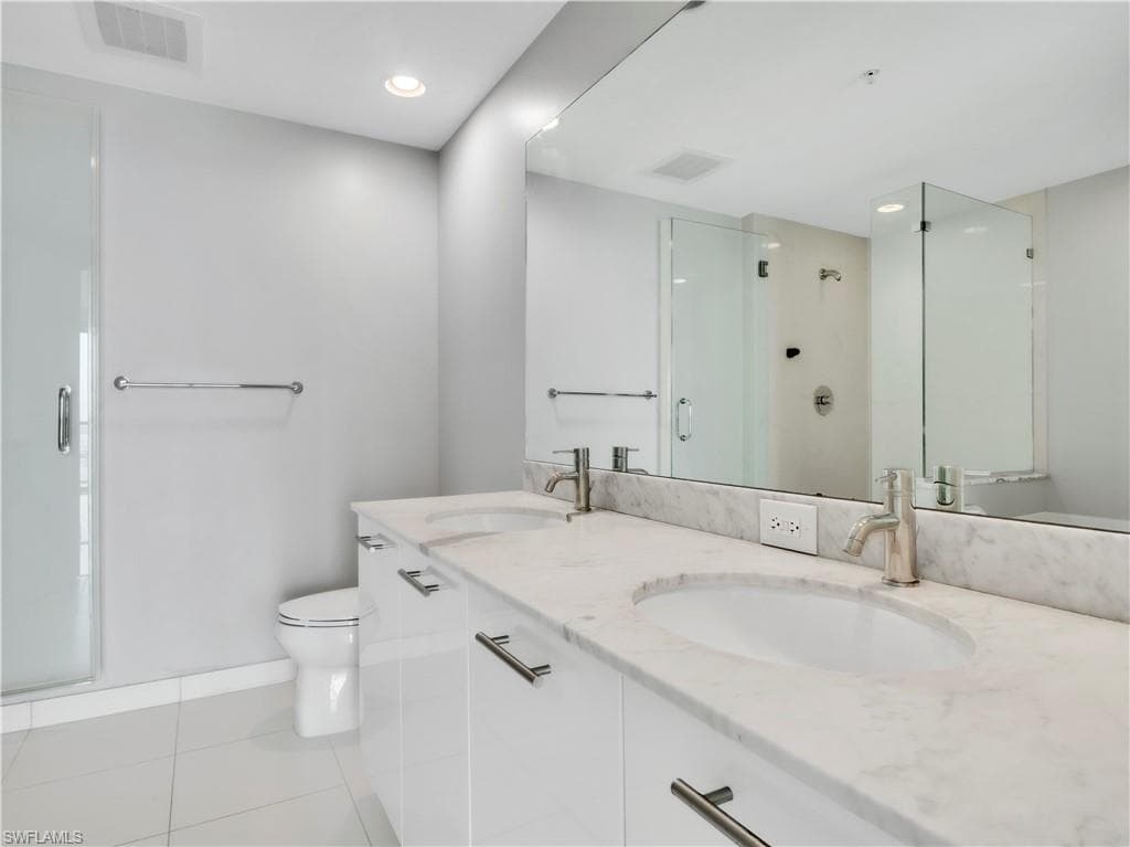 Full bathroom featuring a shower stall, light tile patterned flooring, double vanity, and recessed lighting
