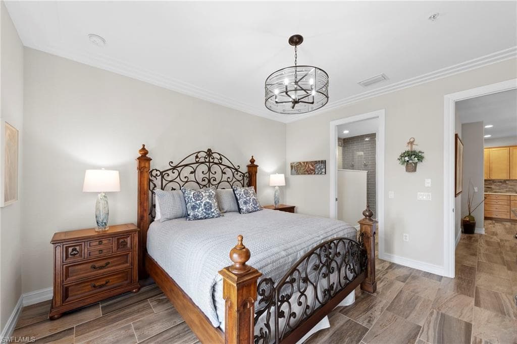 Spacious primary bedroom featuring wood-finish tile flooring and crown molding. NEW TILE FLOOR (2018)