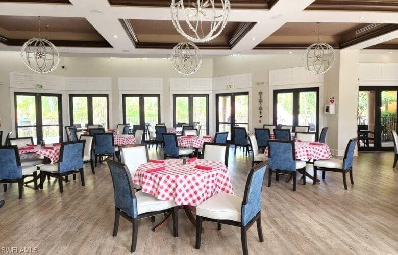 The amenities center with spacious dining area featuring multiple sets of French doors, and coffered ceilings.
