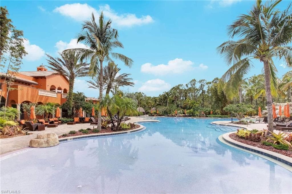 Expansive custom pool with a curved design and a surrounding paver patio