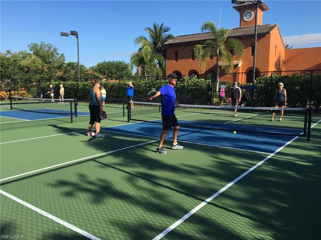 Multiple pickleball courts featuring lighting fixtures.