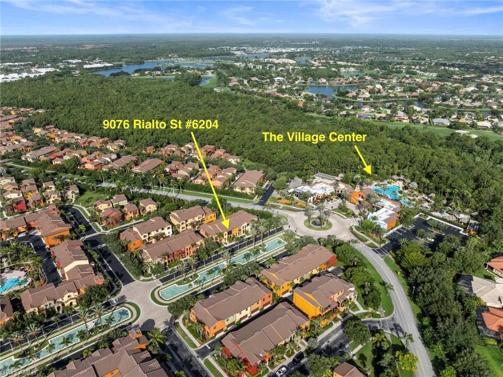 Aerial perspective showcasing a residential community with Mediterranean-inspired architecture and surrounding green spaces
