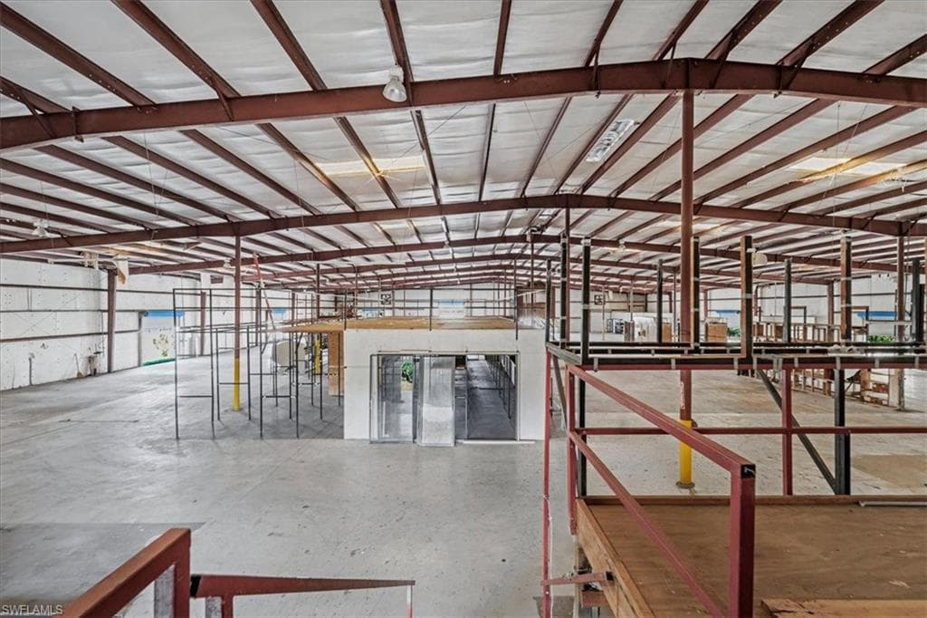 Spacious industrial interior featuring a high, exposed metal beam ceiling with white insulation panels