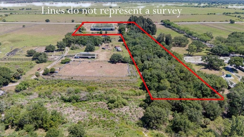 Expansive rural property featuring substantial acreage, a mixture of cleared and wooded land, and visible agricultural structures