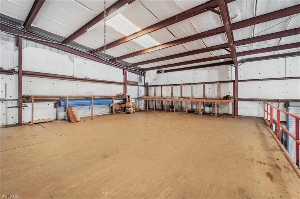 Spacious mezzanine level featuring a wood floor and red metal railing