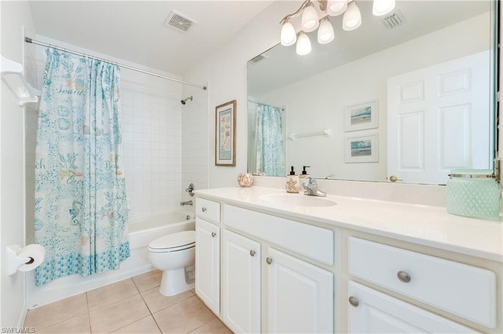 Full guest bathroom featuring a white vanity with integrated sink, a large wall-mounted mirror, and a combination tub/shower
