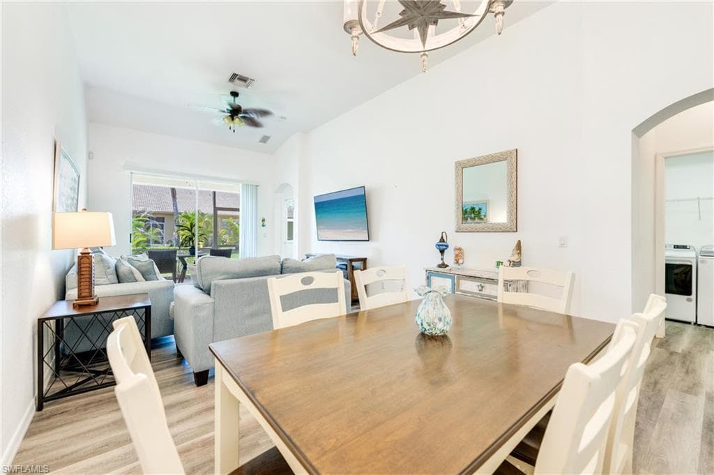 Spacious open-concept interior featuring light wood-finish flooring and vaulted ceilings