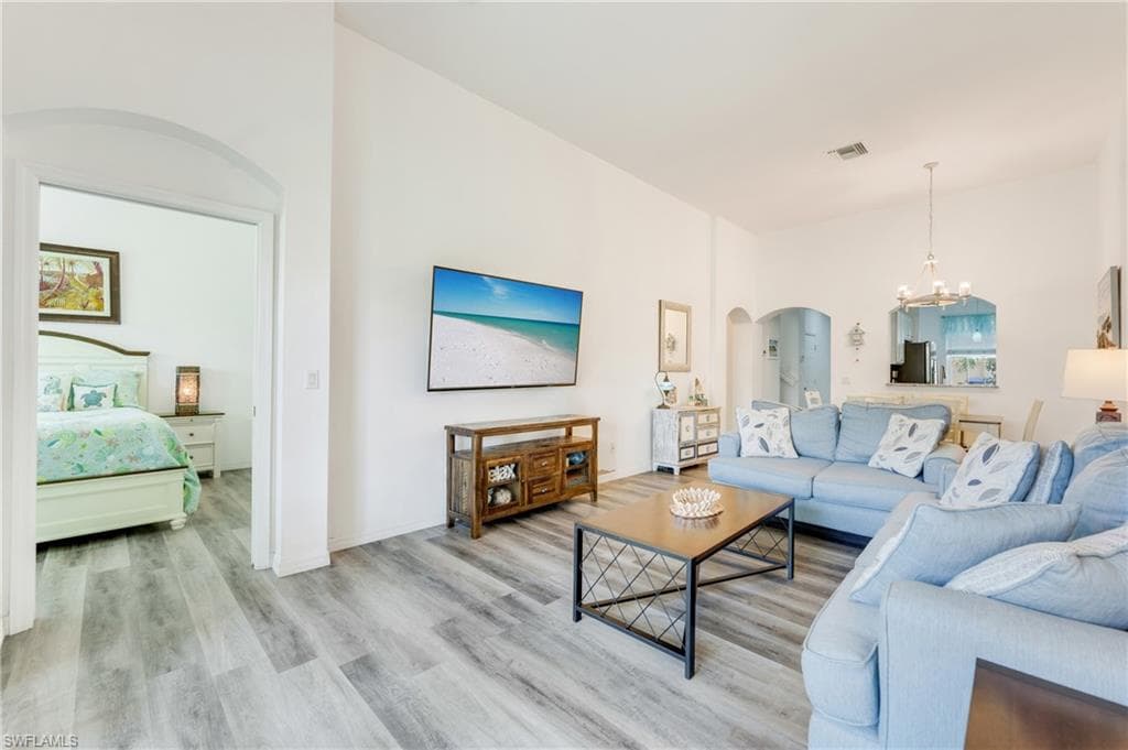Spacious living area featuring light LVP flooring, high ceilings