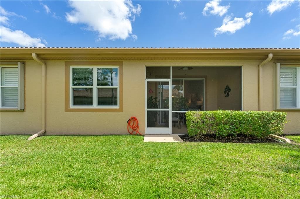 Expansive green lawn bordering the screened lanai