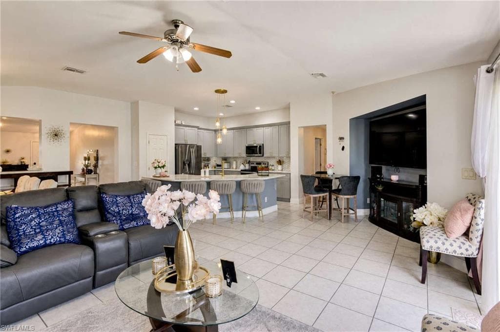 Open-concept living area with tile flooring, a ceiling fan, and recessed lighting