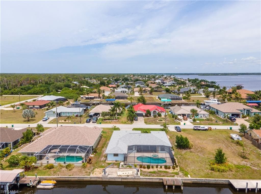Waterfront property featuring a screened-in pool, private dock, and direct canal access