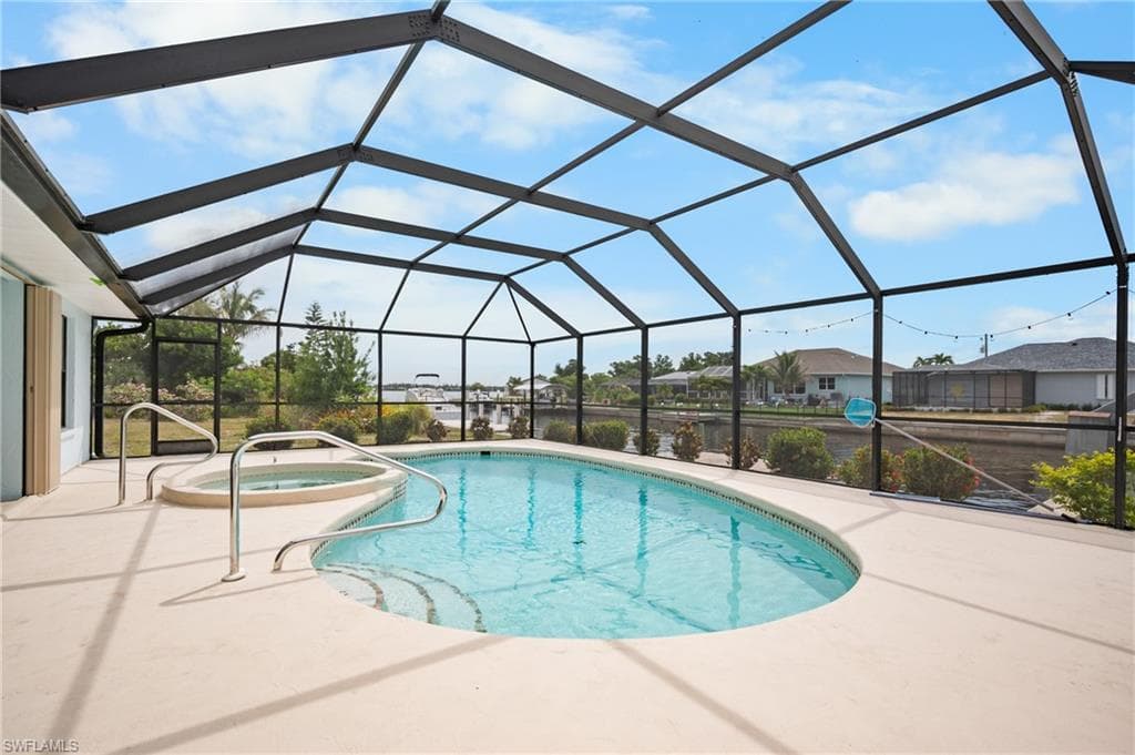 Screened enclosure featuring a pool and integrated spa
