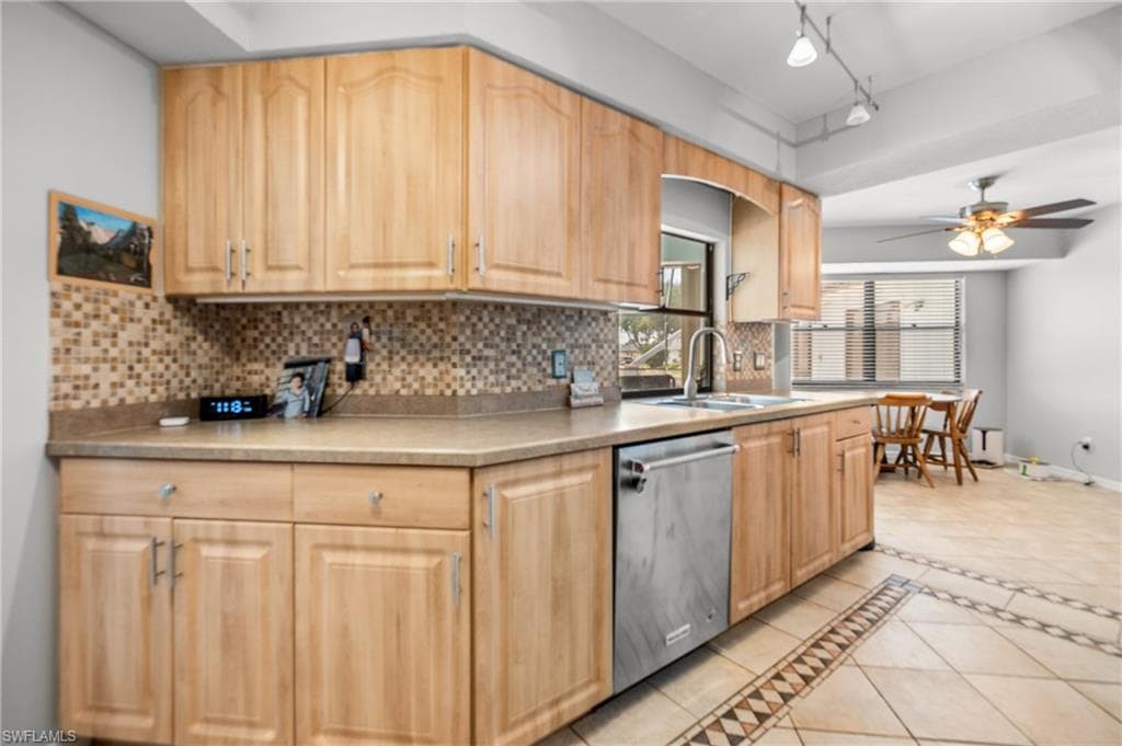 Kitchen featuring light wood cabinetry with brushed nickel hardware, mosaic tile backsplash, and light-toned countertops