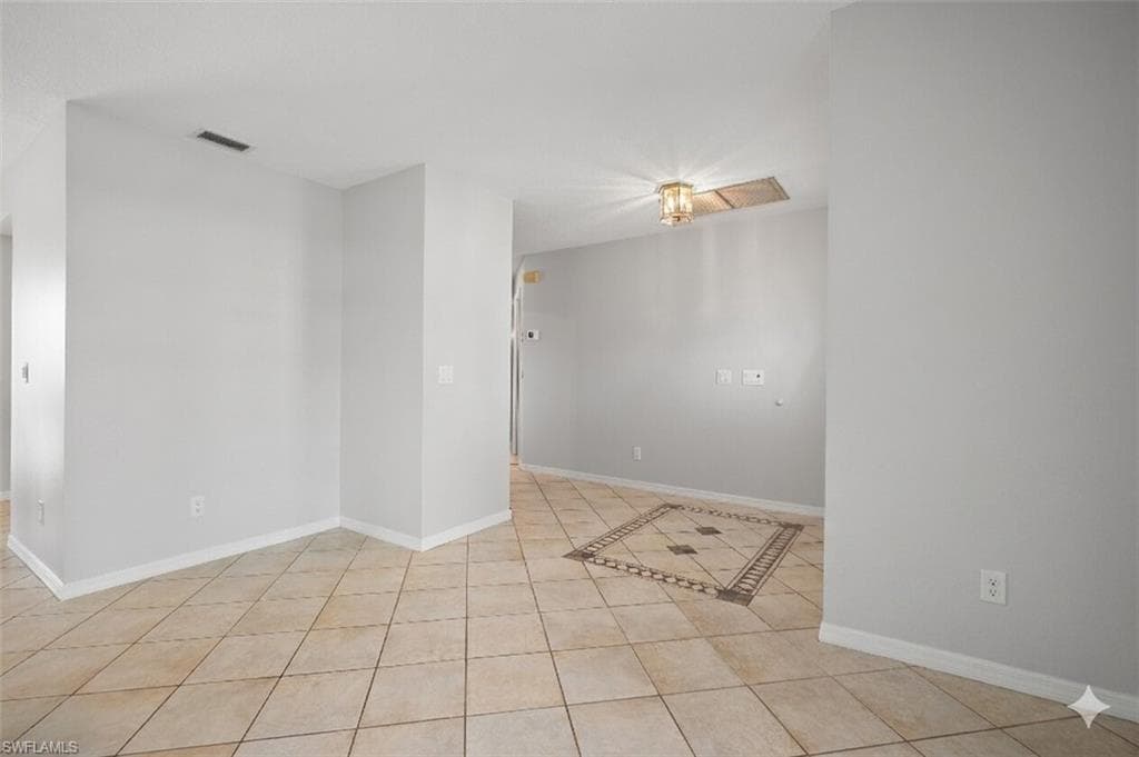 Light-toned ceramic tile flooring with a decorative inset pattern