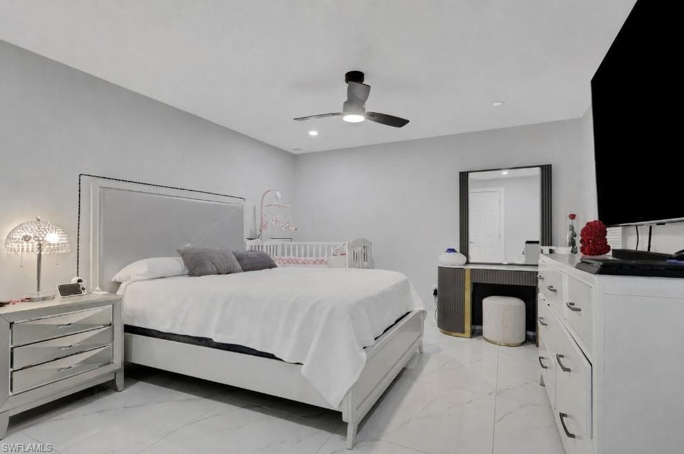 Spacious room featuring light-colored walls, large format tile flooring, a modern ceiling fan with integrated lighting, and recessed ceiling lights