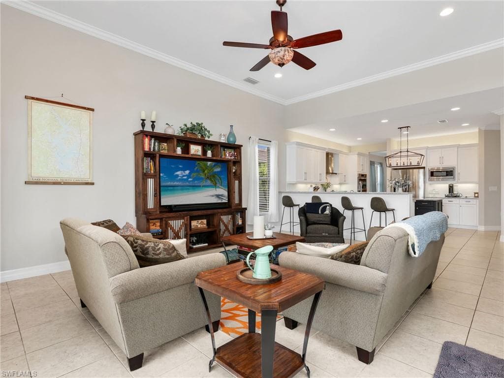 Open-concept living area featuring high vaulted ceilings, crown molding, and recessed lighting