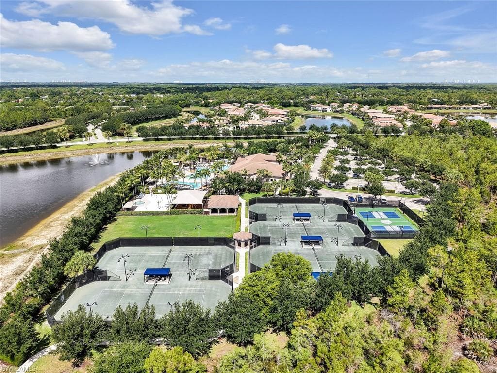 Aerial perspective showcasing multiple tennis courts, a dedicated pickleball court, and a clubhouse with a resort-style pool
