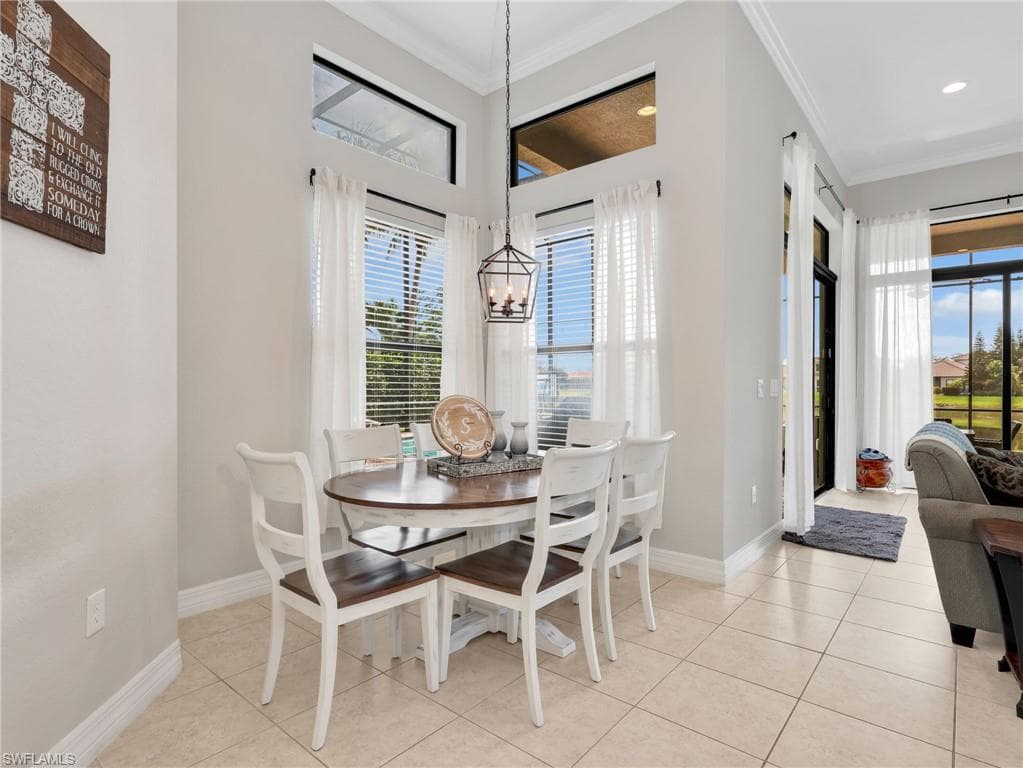 Dining area featuring high ceilings, transom windows, ceramic tile flooring, and direct access to an enclosed patio