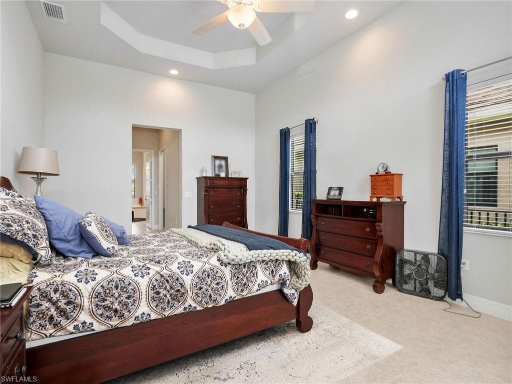 Spacious Master room featuring a tiered tray ceiling and tile flooring