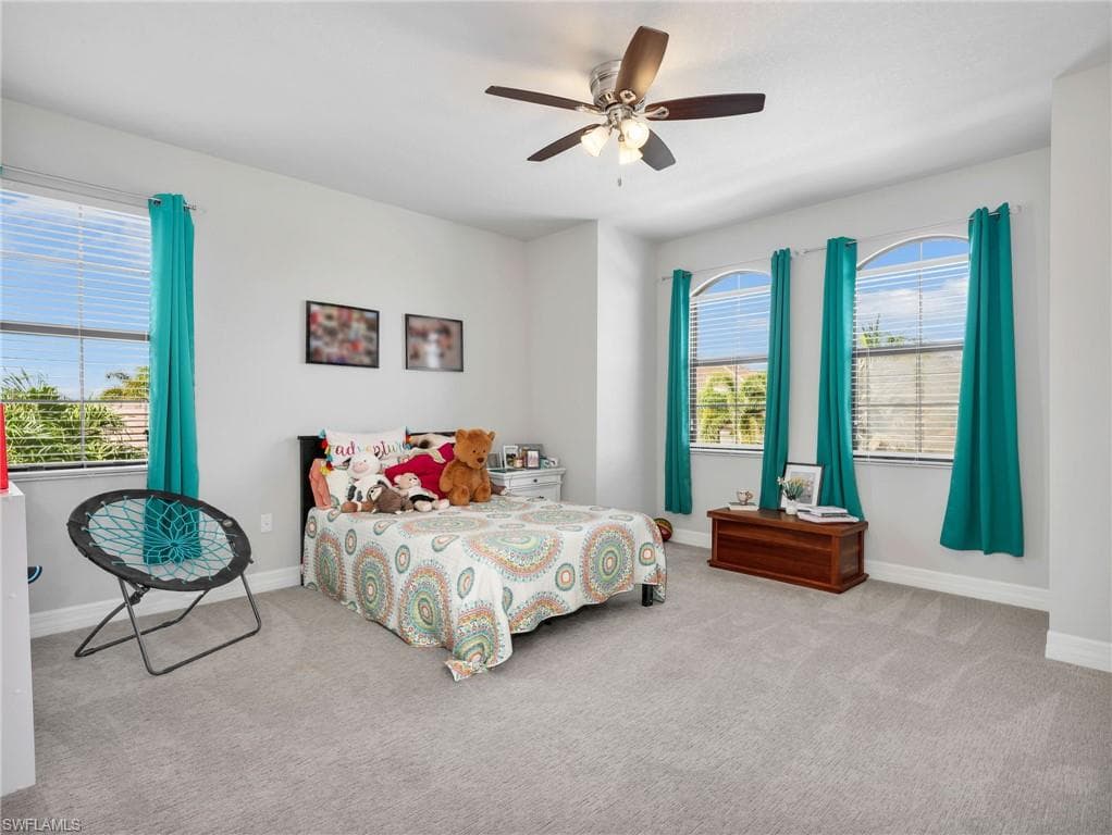 Spacious room featuring light gray carpeting and three arched windows with blinds