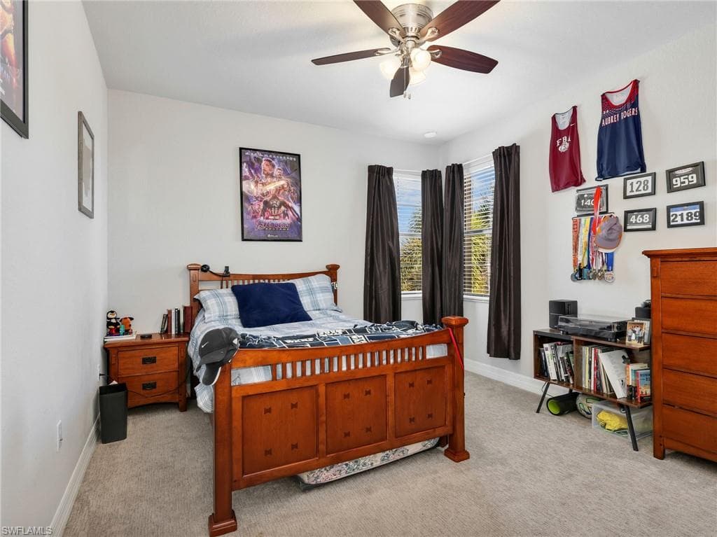 Carpeted room featuring a ceiling fan with integrated lighting, a bay window with blinds, and neutral wall tones