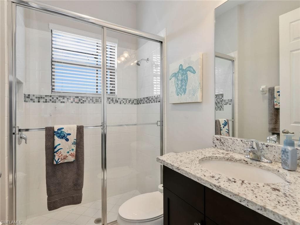 Bathroom guest suite featuring a glass-enclosed shower with white subway tile, mosaic accent tile, and a window with blinds